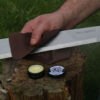 The Compact Blade Care Kit's Blade Balm being applied with the microfibre cloth to a woodland bushcraft blade for protection for corrosion.